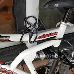 Thin lock cable on a bicycle (that can be cut) is only wrapped around frame and rack